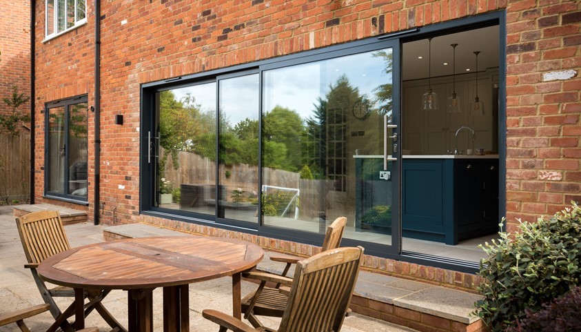 Aluminium sliding doors on a brick extension in Burford