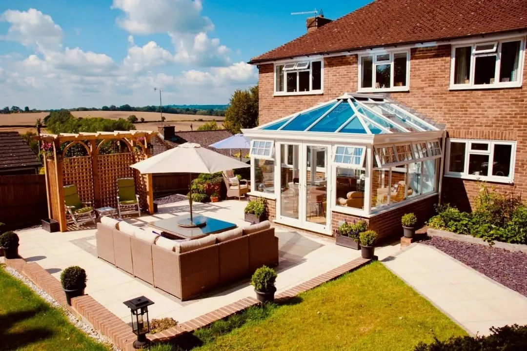 Glass conservatory roof on a brick house with a paved terrace and open countryside beyond, Faringdon