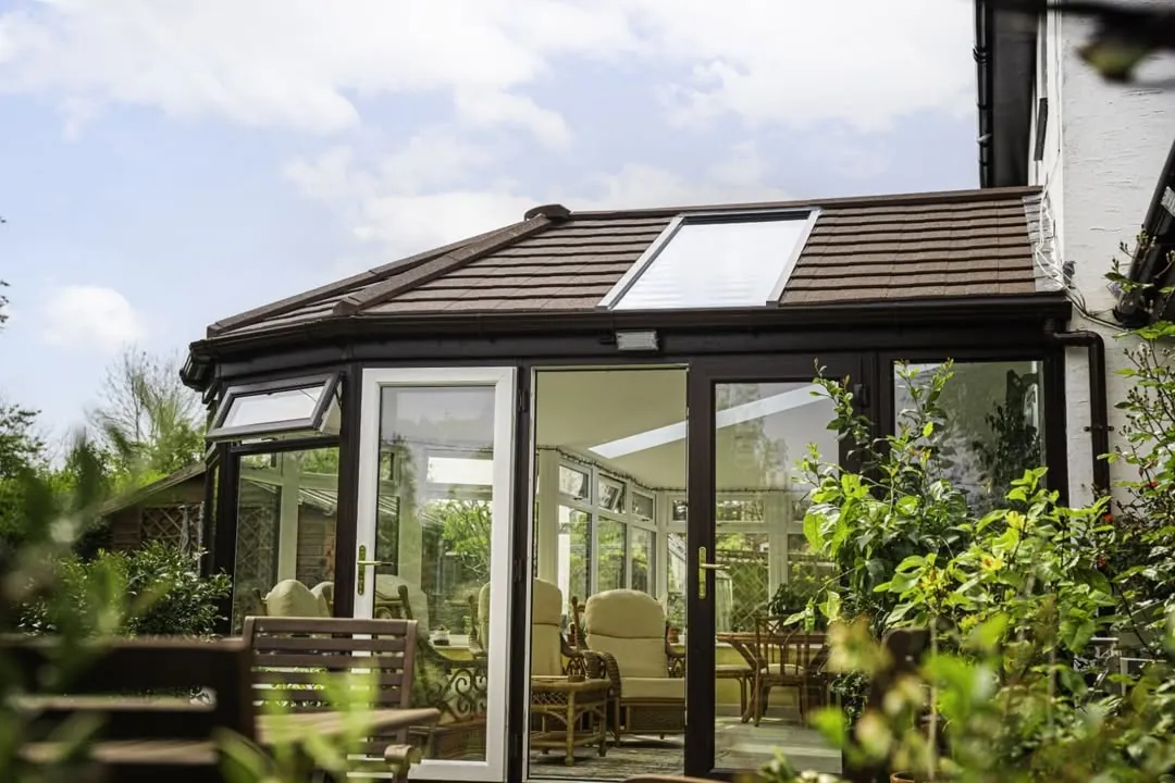 Brown tiled conservatory roof with a roof window above French doors, Kidlington