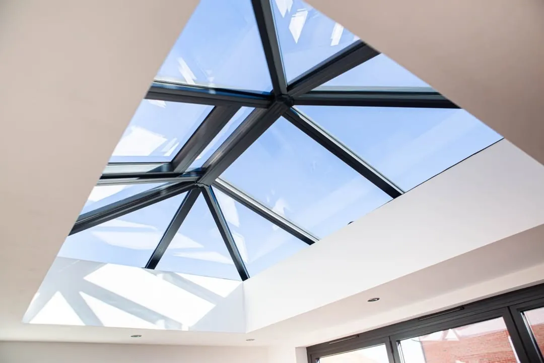 Anthracite grey glazed roof lantern seen from inside against a blue sky, Highworth