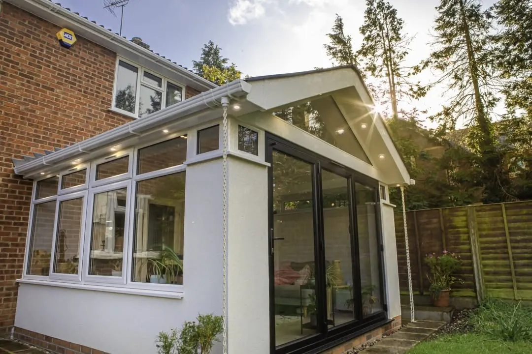 Anthracite grey aluminium bifold doors on a white garden room extension with a glazed roof, Headington, Oxford
