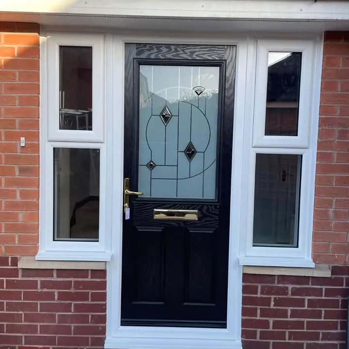 Black composite front door with decorative leaded glass, flanked by white casement side windows, Priory Vale