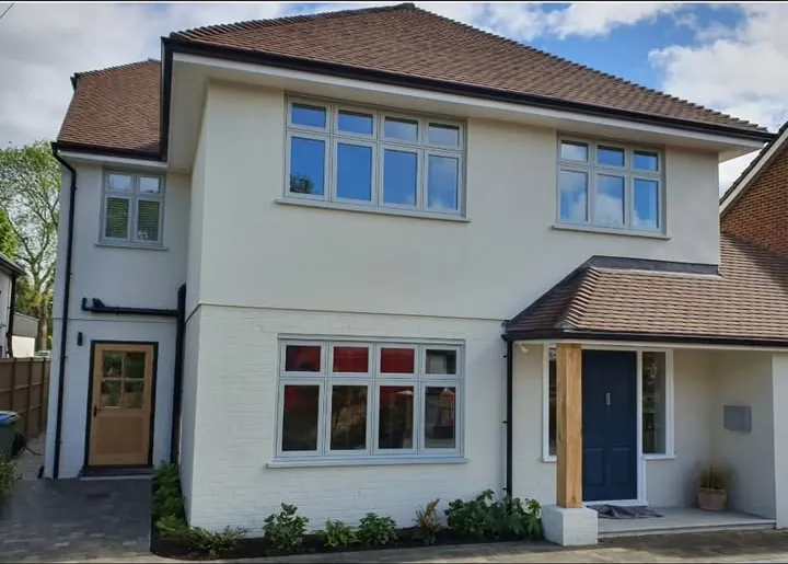 Light grey casement windows across a white rendered detached house with a navy front door, Calcot, Reading