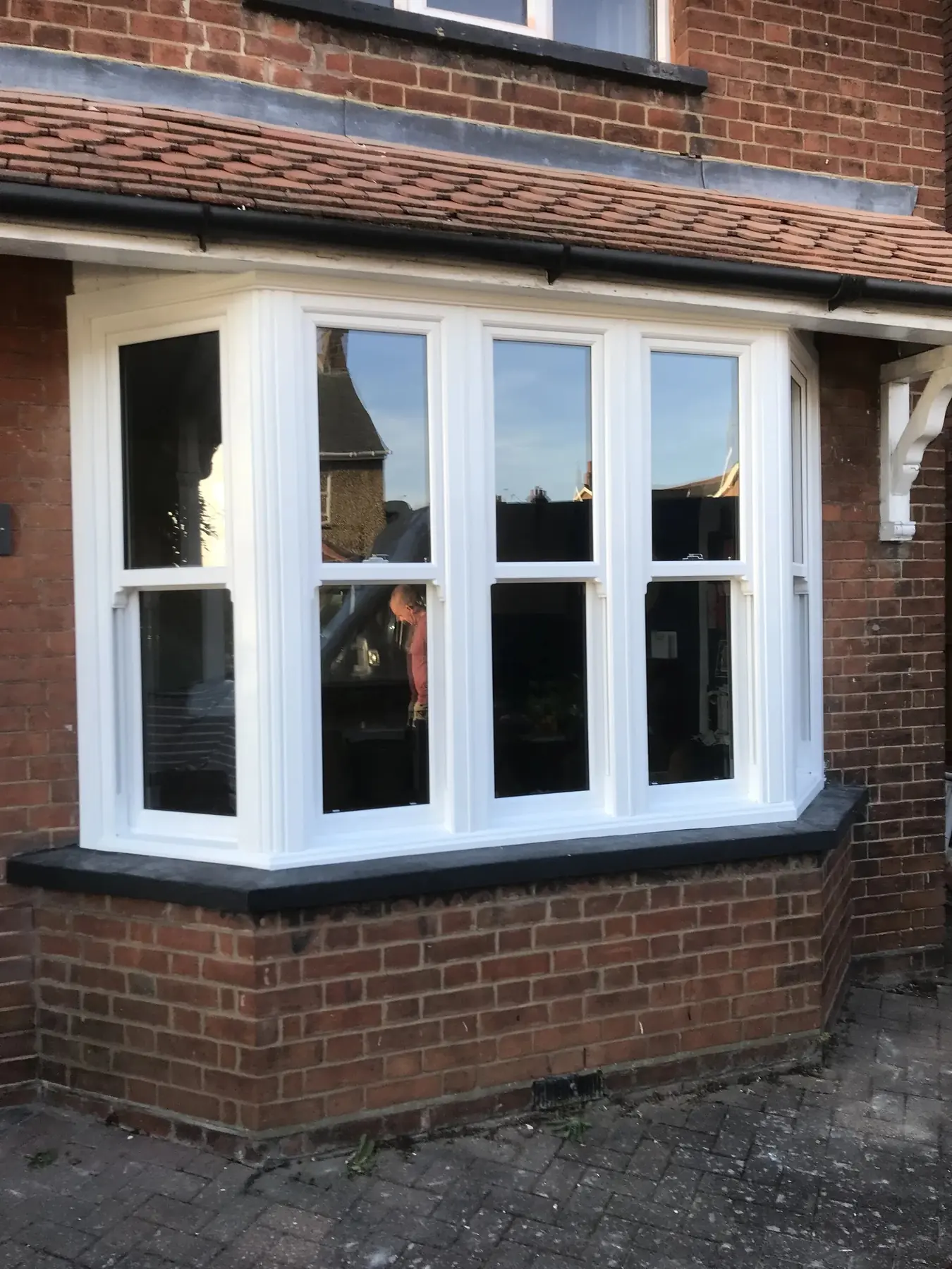 White sliding sash bay window on a red brick Victorian house