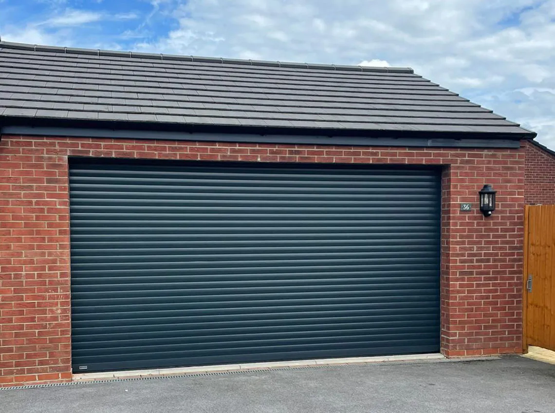 Anthracite insulated roller door on a new-build red-brick double garage