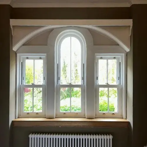 Interior of a bay with a central arched sash and flanking sliding sashes