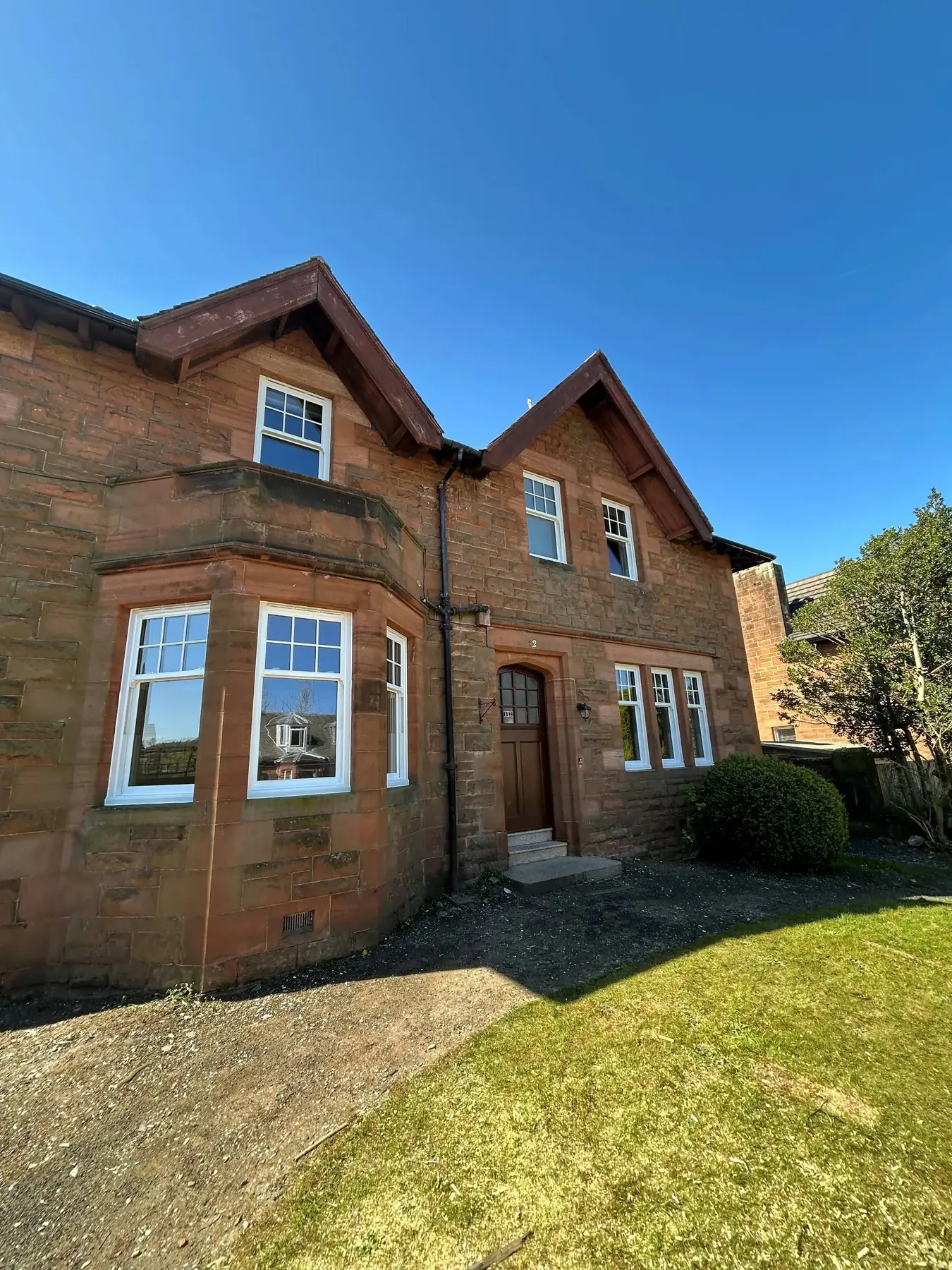 Red sandstone house with white sliding sash windows