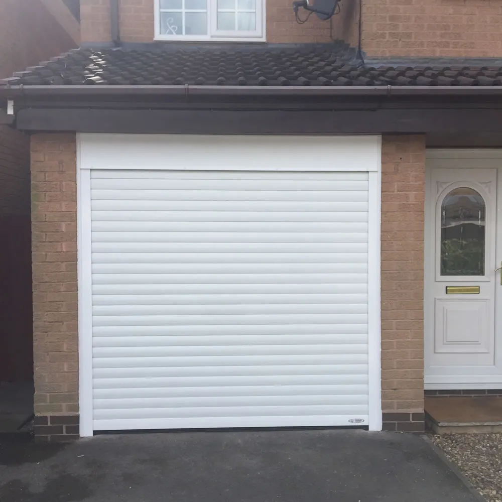 White insulated roller door face-fixed to a single garage beside a front door