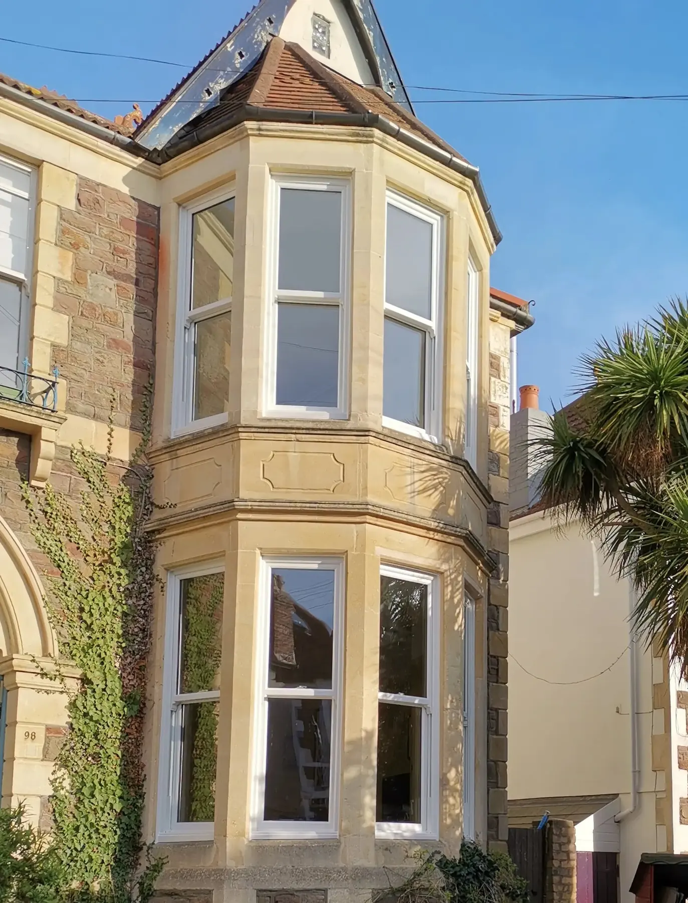 Victorian stone villa with white sliding sash bay windows