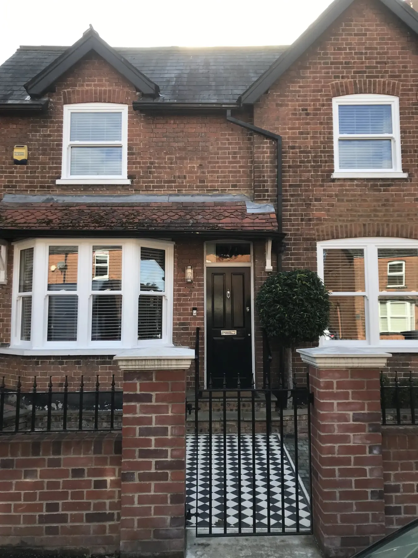 Victorian brick terrace with white sliding sash windows and railings